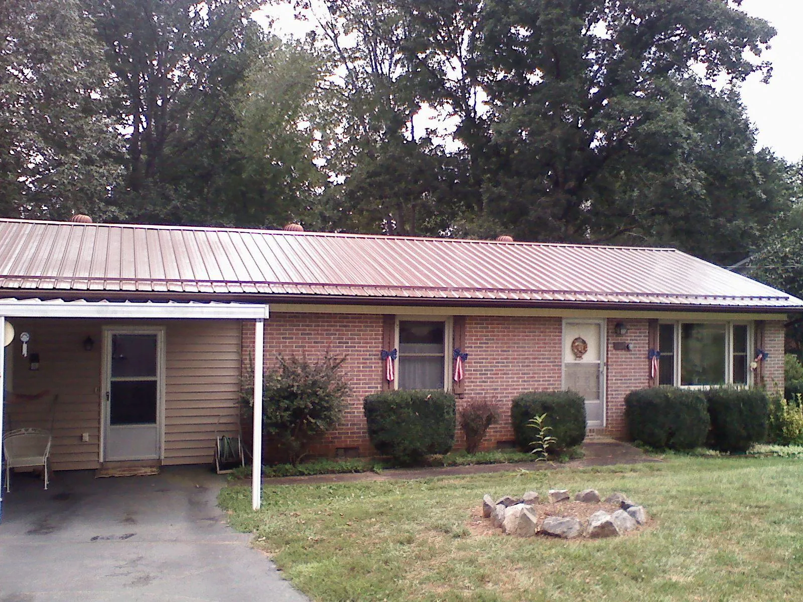 Bronze metal roof and carport on a brick ranch home — Roof Repair work by our crew in New London